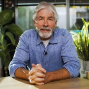 Christopher Green seated at a table with hands clasped