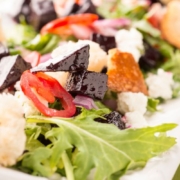 Close-up of a beet salad with crumbled cheese and field greens
