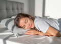 Woman sleeping with head on a pillow in bed