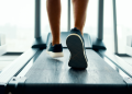 Close-up of a person's lower legs and sneakers walking on a treadmill