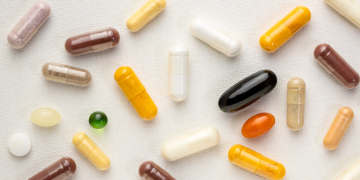 Vitamin supplement capsules and softgels on a white background