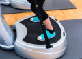 Woman on vibration plate at gym