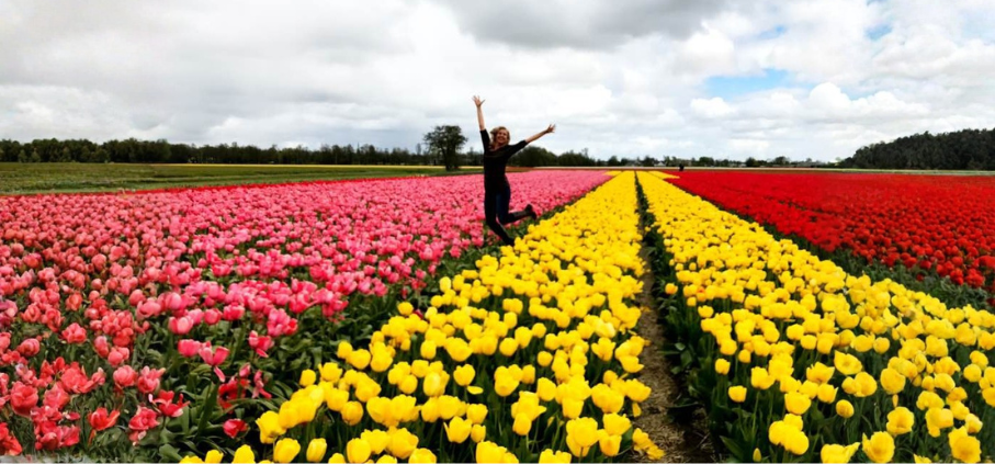 woman jumping in tulips