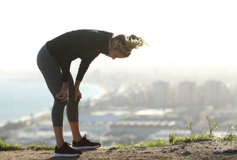 Female runner slumps over to rest