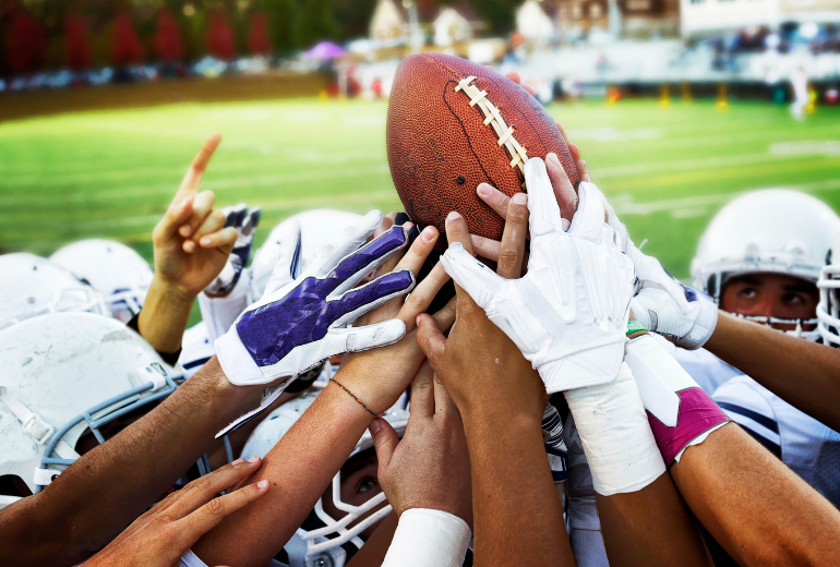 Football players fight to catch a football